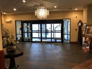 a lobby with a chandelier and a large glass door at Chateau Saint John Trademark Collection by Wyndham in Saint John