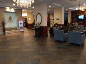 a lobby with a waiting room with couches and a mirror at Chateau Saint John Trademark Collection by Wyndham in Saint John