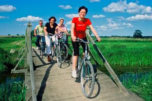 grupa ludzi jeżdżących rowerami na moście w obiekcie Hotel Am Brauhaus w mieście Waren