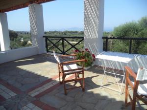 eine Terrasse mit Stühlen, einem Tisch und Aussicht in der Unterkunft Ilis Villas in Kyllini