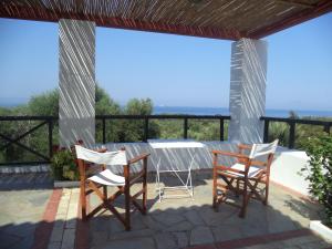 einen Tisch und Stühle auf einer Terrasse mit Meerblick in der Unterkunft Ilis Villas in Kyllini