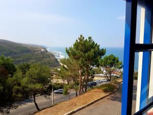 uma vista para o oceano a partir de uma janela em Magoito Sea View Apartment em Lisboa