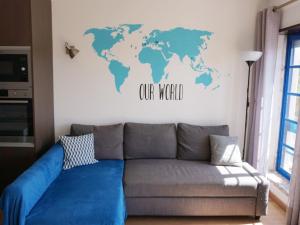 uma sala de estar com um sofá e um mapa do mundo na parede em Magoito Sea View Apartment em Lisboa