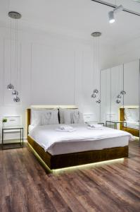 um quarto branco com uma cama grande e 2 mesas em Room 25 Belgrade em Belgrado