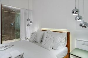 uma cama branca com almofadas brancas num quarto em Room 25 Belgrade em Belgrado