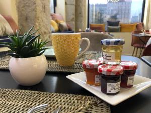 une table avec un plateau avec des bocaux de confiture dans l'établissement Hotelo Lyon Charité, à Lyon