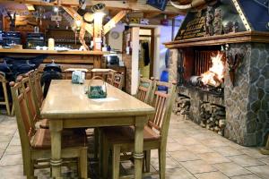 a table and chairs with a fireplace in a restaurant at Steak Restaurant Penzion Country Saloon in Klatovy