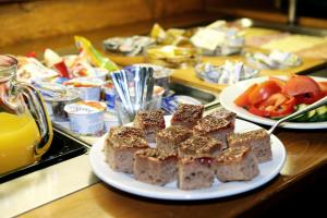 a table with a plate of brownies and fruits and vegetables at Steak Restaurant Penzion Country Saloon in Klatovy