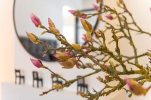 a branch with pink flowers in front of a mirror at Zandvoort Studio in Zandvoort