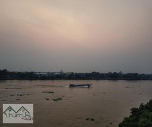 um barco na água em um rio em Baanthanam Nont em Nonthaburi