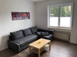 een woonkamer met een bank en een tafel bij Ferienwohnung "am Ochsentor" in Andernach