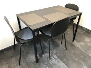 een zwarte tafel en twee stoelen er omheen bij Ferienwohnung "am Ochsentor" in Andernach