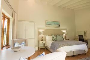 1 dormitorio con 1 cama, 1 mesa y 1 silla en Oakvale Lodge, en Ciudad del Cabo