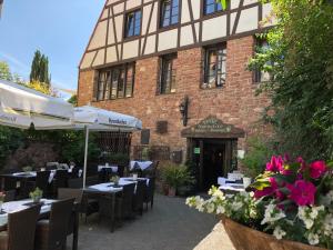 un ristorante con tavoli e sedie di fronte a un edificio di Hotel Weingärtner a Mannheim