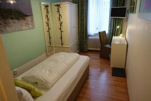 - une chambre avec un lit et une chaise dans l'établissement Hotel Villa Konstanz, à Berlin