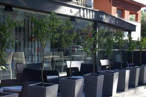 a row of chairs and potted plants in front of a building at Hotel Sitges in Sitges