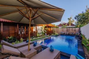 uma piscina exterior com cadeiras e um guarda-sol em Lembongan Small Heaven Bungalow em Nusa Lembongan