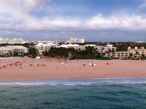 - une plage avec des chaises, des parasols et des bâtiments dans l'établissement The Lago Mar Beach Resort and Club, à Fort Lauderdale