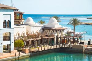 a building on the water next to the ocean at Marina Residence Suites Port Ghalib in Port Ghalib