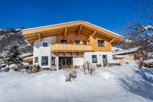 ein Haus im Schnee mit einem Holzdach in der Unterkunft Apartment 5 Peaks in Zell am See