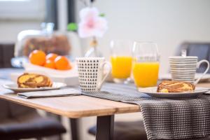 a table with two plates of food and orange juice at Apartments Bakota in Omiš