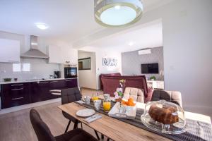 a kitchen and a living room with a table with food on it at Apartments Bakota in Omiš