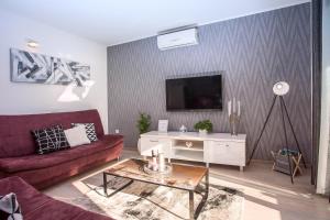 a living room with a couch and a tv at Apartments Bakota in Omiš