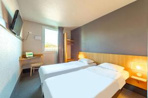 Giường trong phòng chung tại B&B HOTEL Toulon Ollioules