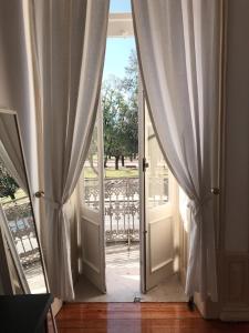 een open deur met gordijnen en een veranda bij Hotel Jardim in Coimbra