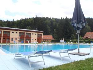 einen Pool mit 2 Stühlen und einem Sonnenschirm in der Unterkunft Hotel Bazant in Karlsbad