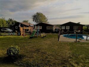 um quintal com um parque infantil e uma piscina em Osada Rybacka em Jastrzębia Góra