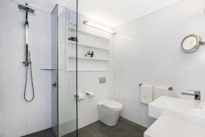 een badkamer met een douche, een toilet en een wastafel bij Seacombe House Motor Inn Port Fairy in Port Fairy