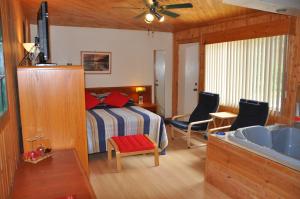 a bedroom with a bed and a bathroom with a sink at Le Boisé du Lac in Mont-Tremblant