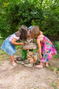 Zwei Mädchen küssen einen Teddybären mit einem Zeichen, das wohlwollend liest in der Unterkunft Domaine De La Boulaie in Treize-Vents