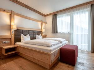 a bedroom with a large bed with a wooden headboard at Apartment Kristall in Finkenberg