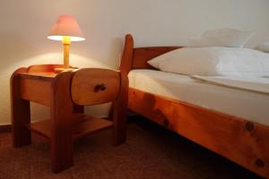 a bedroom with a bed and a desk with a lamp at Fodor Hotel in Gyula