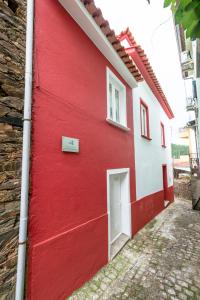 een rood-wit gebouw met een deur bij Casa do Silverio - Barroca in Barroca