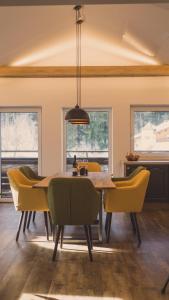 a dining room with a table and yellow chairs at Apartment NinetyFour in Annaberg im Lammertal