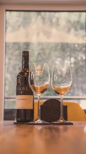 a bottle of wine and two wine glasses on a table at Apartment NinetyFour in Annaberg im Lammertal