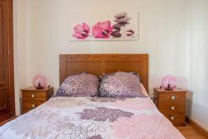 um quarto com uma cama com duas flores cor-de-rosa em Apartamento Lince em Matalascañas