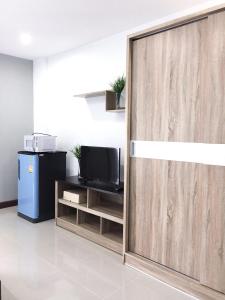 - une porte coulissante en verre avec une télévision dans la chambre dans l'établissement โรงแรม เดอะริช ราชพฤกษ์ โฮเทล แอนด์ เรสซิเดนซ์, à Nonthaburi