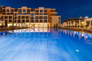 a large pool in front of a hotel at night at Premier Fort Club Hotel - Full Board in Sunny Beach