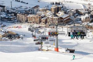 un groupe de personnes sur une remontée mécanique dans la neige dans l'établissement HelloChalet - Maison Rêve Blanc - Ski to door with Matterhorn view, à Breuil-Cervinia