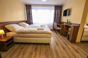 een hotelkamer met een bed, een bureau en een raam bij Hotel SiLL in Kielce