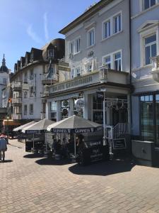 un edificio con ombrelloni su una strada cittadina di Hajo´s Germania Lodge & Irish Pub a Rüdesheim am Rhein