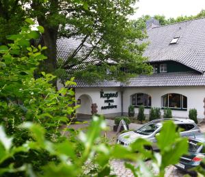 un bâtiment avec une voiture garée devant lui dans l'établissement Hotel am Rugard, à Bergen auf Rügen