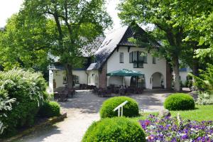 une maison avec des tables et des chaises dans un jardin dans l'établissement Hotel am Rugard, à Bergen auf Rügen