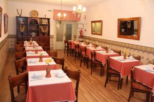 een restaurant met tafels en stoelen met rode tafelkleden bij Residencial Carvalho in Estremoz