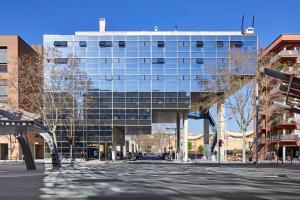 un grand bâtiment en verre sur le côté d'une rue dans l'établissement Unite Hostel Barcelona, à Barcelone