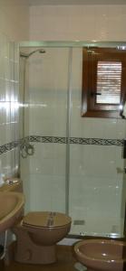 a bathroom with a toilet and a glass shower at Hostal Rural Las Terrazas de la Alpujarra in Bubión